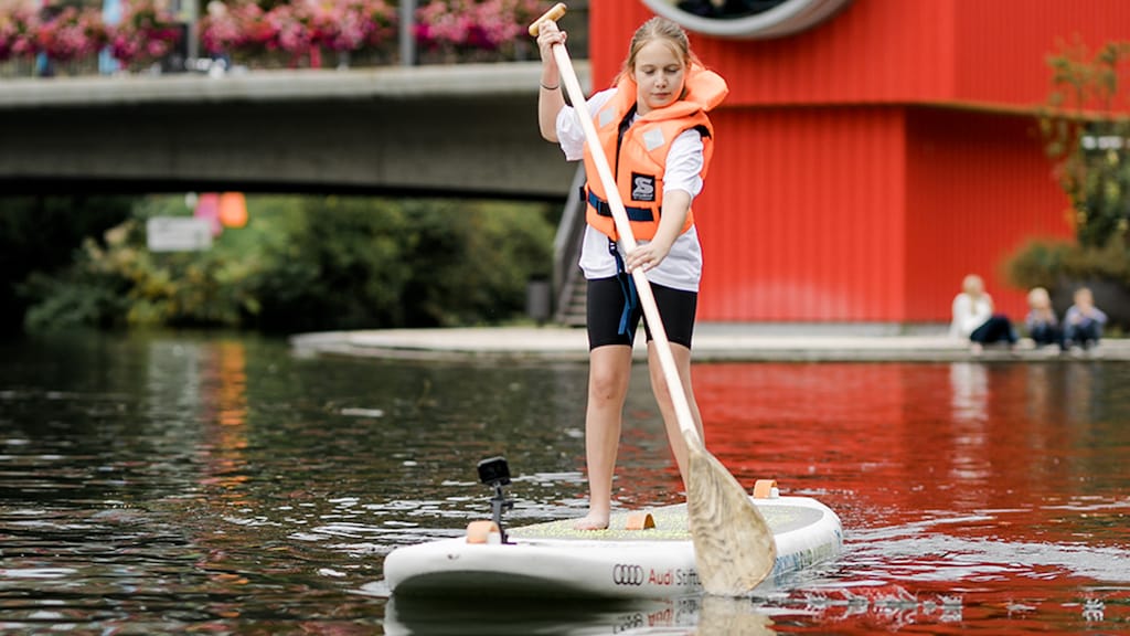 Eine Schülerin testet das SUP auf dem Neckar aus.